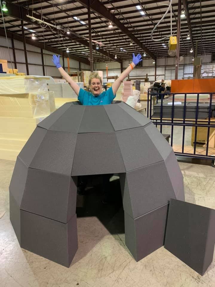 SWFT team member celebrating inside a custom-fabricated foam igloo on the shop floor